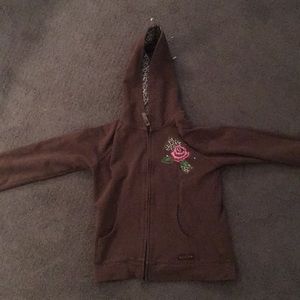 A brown sweater rose designed on sleeve and chest